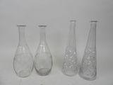 trois vases en verre transparent posés l'un à côté de l'autre sur une surface blanche