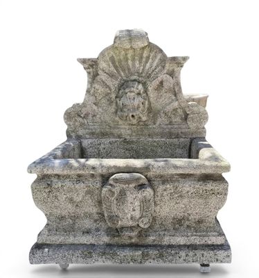 a stone sink with a lion head on it