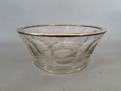 une photo représentant un bol en verre à bord argenté posé sur une table