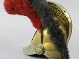 a gold helmet with a red feather on top of it