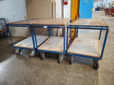 three wooden tables on wheels in a room