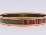 un gros plan d'un bracelet rouge et vert posé sur une surface blanche