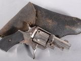 un pistolet dans un étui en cuir posé sur une surface blanche