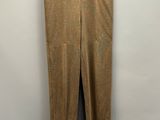 a brown pants hanging on a hanger against a wall