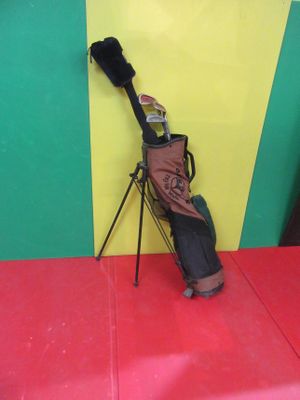 a bag of golf clubs on a tripod next to a yellow and green wall
