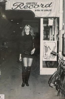 photographie en noir et blanc d'une femme en jupe courte et bottes