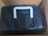 a black suitcase with a white handle in a cardboard box