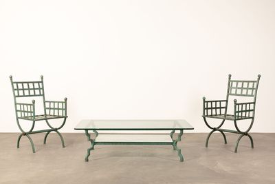 three chairs and a table in a room with a white wall