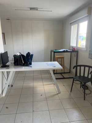 une pièce dans laquelle se trouvent une table, des chaises et une télévision