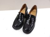 a pair of black shoes sitting on top of a white table