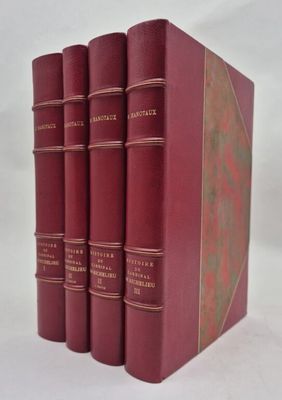 quatre livres rouges sont empilés les uns sur les autres sur une surface blanche