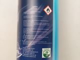 a close up of a bottle of blue liquid on a white surface