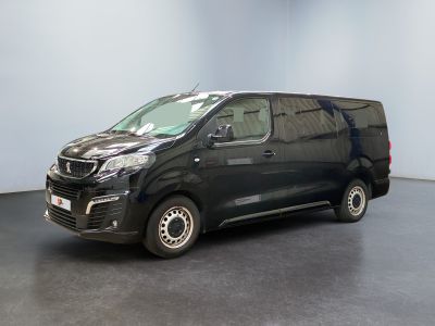 La camionnette noire est garée dans une pièce au sol gris.
