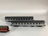 three toy trains sitting next to each other on a white surface
