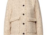 a woman is wearing a white jacket with black buttons