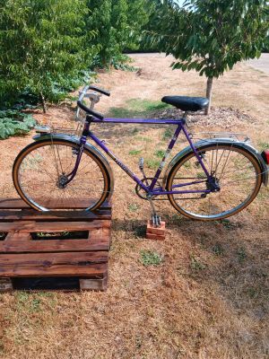 a purple bike that is parked on a wooden pallet