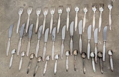 many forks and spoons laid out on a table