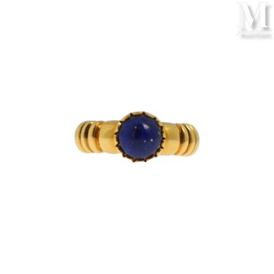 un gros plan d'une bague en or sertie d'un lapis-lazuli