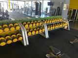 a gym area with a row of dumbs and a row of dumbs