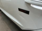 a close up of a white car with a sticker on it
