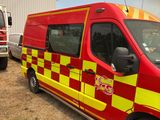 a red and yellow fire truck parked next to a white fire truck
