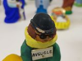 toy figurines of a man in a green coat and hat with a sign on his chest