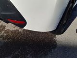 a close up of a white car with a red tail light