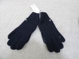 pair of black gloves on a bed with a tag on it