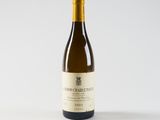 a bottle of white wine sitting on top of a white table