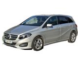 une Mercedes Classe B argentée garée devant un fond blanc