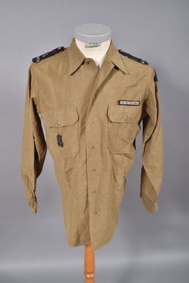 un uniforme militaire sur un mannequin, devant un fond gris