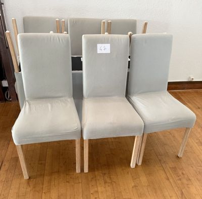 quatre chaises blanches, avec une étiquette de prix, posées sur un plancher en bois