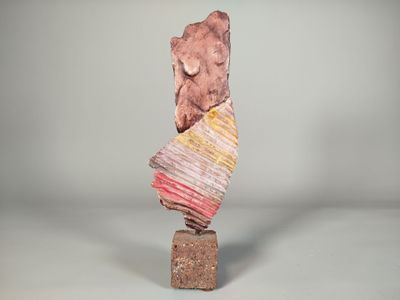un gros plan sur une sculpture représentant un rocher posé sur un bloc