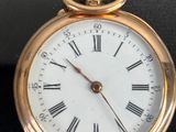 a gold pocket watch with roman numerals on the face