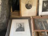 a lot of framed pictures on a table in a room