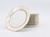 a stack of white plates with gold rims on them