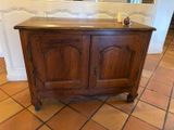 a wooden cabinet in the middle of a tiled floor