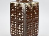 a brown and white vase sitting on a table