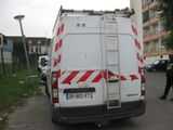 a white van with red and white stripes parked on the side of the road