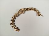 a close up of a gold bracelet with a clock on it