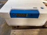 une boîte blanche surmontée d'une horloge numérique bleue