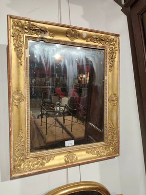 un miroir accroché au mur au-dessus d'une chaise