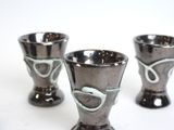 three cups that are sitting on a white table