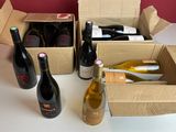 Plusieurs bouteilles de vin sont posées dans une boîte en carton sur une table