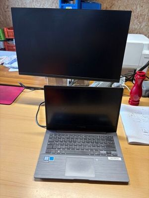 un ordinateur portable posé sur un bureau, avec un écran posé dessus