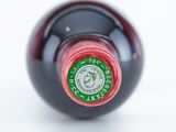 a close up of a wine bottle with a red cap