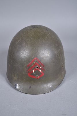 un vieux casque orné d'un losange rouge, posé sur une table