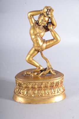 figurine en laiton représentant un homme en train de danser, posée sur un socle