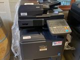 a printer that is sitting on the floor next to a barrel