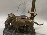 statue en bronze représentant un chien tenant un oiseau dans la gueule, posée sur un socle